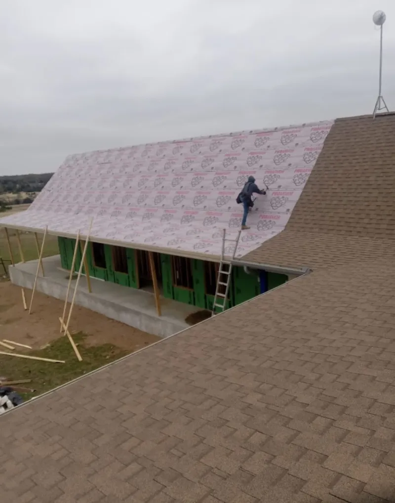 Worker preparing underlayment for a metal roof installation in Palmetto Bay